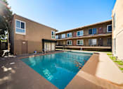Thumbnail 6 of 9 - A swimming pool in a courtyard surrounded by buildings.