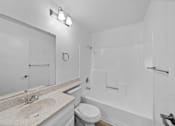 Thumbnail 8 of 8 - A white bathroom with a sink, toilet, and bathtub.