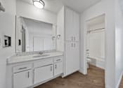Thumbnail 10 of 13 - A bathroom with a sink, mirror, and cabinets.