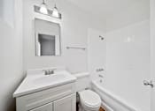 Thumbnail 7 of 12 - A white bathroom with a toilet, sink, and bathtub.