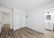 Thumbnail 4 of 12 - A white room with a wooden floor and a small white cabinet.