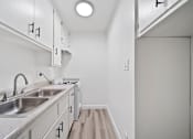 Thumbnail 9 of 12 - A kitchen with a sink and a stove top.