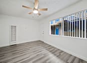 Thumbnail 11 of 12 - A room with a ceiling fan and a window with bars.