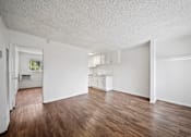 Thumbnail 1 of 12 - A large empty room with wooden floors and white walls.