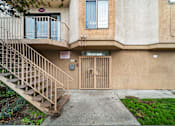 Thumbnail 3 of 20 - A building with a staircase leading to a door with a sign on it.