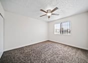 Thumbnail 8 of 14 - A room with a ceiling fan and carpeted floor.