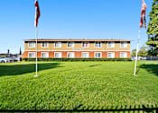 Thumbnail 2 of 14 - A hotel with a red flag on the left and a white flag on the right.
