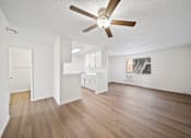 Thumbnail 4 of 14 - A room with a ceiling fan and wooden flooring.
