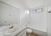 Thumbnail 14 of 14 - A white bathroom with a sink, toilet, and bathtub.