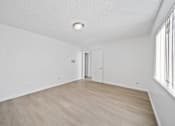 Thumbnail 10 of 14 - A room with a wooden floor and a door.