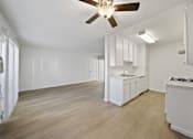 Thumbnail 9 of 14 - A kitchen with white cabinets and a wooden floor.