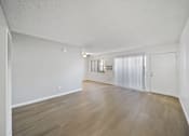 Thumbnail 8 of 14 - A room with wooden flooring and white walls.