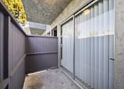 Thumbnail 7 of 14 - A room with a concrete wall and a glass door.