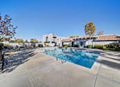Thumbnail 6 of 14 - A swimming pool in a residential area with a house in the background.