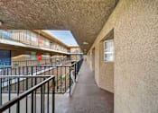 Thumbnail 5 of 14 - A long hallway with a balcony on the left side.