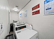 Thumbnail 13 of 14 - A white wall with a red sign and a blue poster.