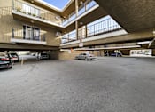 Thumbnail 9 of 14 - A parking garage with cars parked in it.