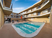 Thumbnail 8 of 14 - A small pool in a courtyard surrounded by buildings.