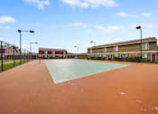 Thumbnail 12 of 18 - A tennis court with a red surface and a green surface in the middle.