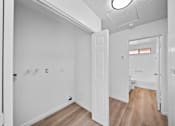 Thumbnail 7 of 11 - A white room with a door and a window.