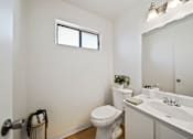Thumbnail 13 of 13 - A white toilet sits next to a sink in a small bathroom.