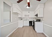 Thumbnail 11 of 13 - A kitchen with white cabinets and a black stove top oven.