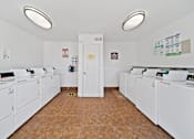 Thumbnail 8 of 13 - A laundromat with rows of washers and dryers.