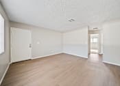 Thumbnail 9 of 13 - A room with wooden floors and white walls.