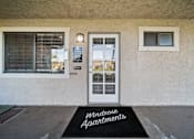 Thumbnail 4 of 13 - The entrance to a building with a sign that says "Windrose Apartments" on the doormat.