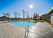 Thumbnail 3 of 13 - A sunny day at a pool with a clear blue sky.