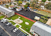 Thumbnail 4 of 5 - A parking lot with cars and a building in the background.