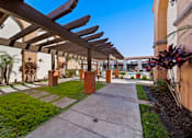 Thumbnail 10 of 70 - A walkway with a roof of wooden beams and brick pillars.