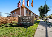 Thumbnail 11 of 70 - Sunset Pointe Apartment Homes sign with flags in front.