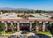 Thumbnail 17 of 70 - A large building with a red tile roof and a parking lot in front.
