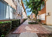 Thumbnail 20 of 70 - A long brick walkway leads between two buildings.