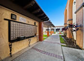 Thumbnail 22 of 70 - A long, narrow walkway with a brick wall and a metal gate.
