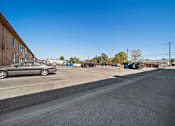 Thumbnail 24 of 70 - A parking lot with a car and a building in the background.
