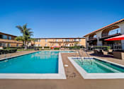 Thumbnail 25 of 70 - A large outdoor swimming pool with a slide and a smaller pool with a fountain.