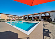 Thumbnail 26 of 70 - A large swimming pool with a red umbrella above it.