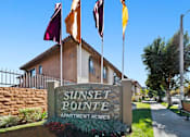 Thumbnail 2 of 70 - Sunset Pointe Apartment Homes sign with flags in front.