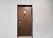 Thumbnail 34 of 70 - A brown door with a silver handle and a number 122 on the top left.