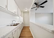 Thumbnail 44 of 70 - A kitchen with white cabinets and a marble countertop.