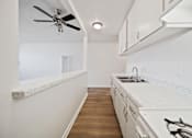 Thumbnail 45 of 70 - A kitchen with white cabinets and a white counter top.