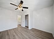 Thumbnail 48 of 70 - A room with a ceiling fan and wooden flooring.