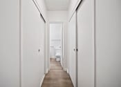 Thumbnail 55 of 70 - A long hallway with a toilet at the end.