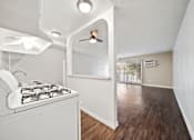 Thumbnail 57 of 70 - A white kitchen with a stove and a fan.