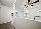 Thumbnail 62 of 70 - A white room with a ceiling fan and a small kitchenette.