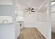 Thumbnail 63 of 70 - A kitchen with a fan on the ceiling and a counter with a sink.