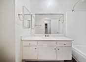 Thumbnail 64 of 70 - A white bathroom with a sink and a mirror.