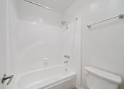 Thumbnail 67 of 70 - A white bathroom with a bathtub, toilet, and sink.